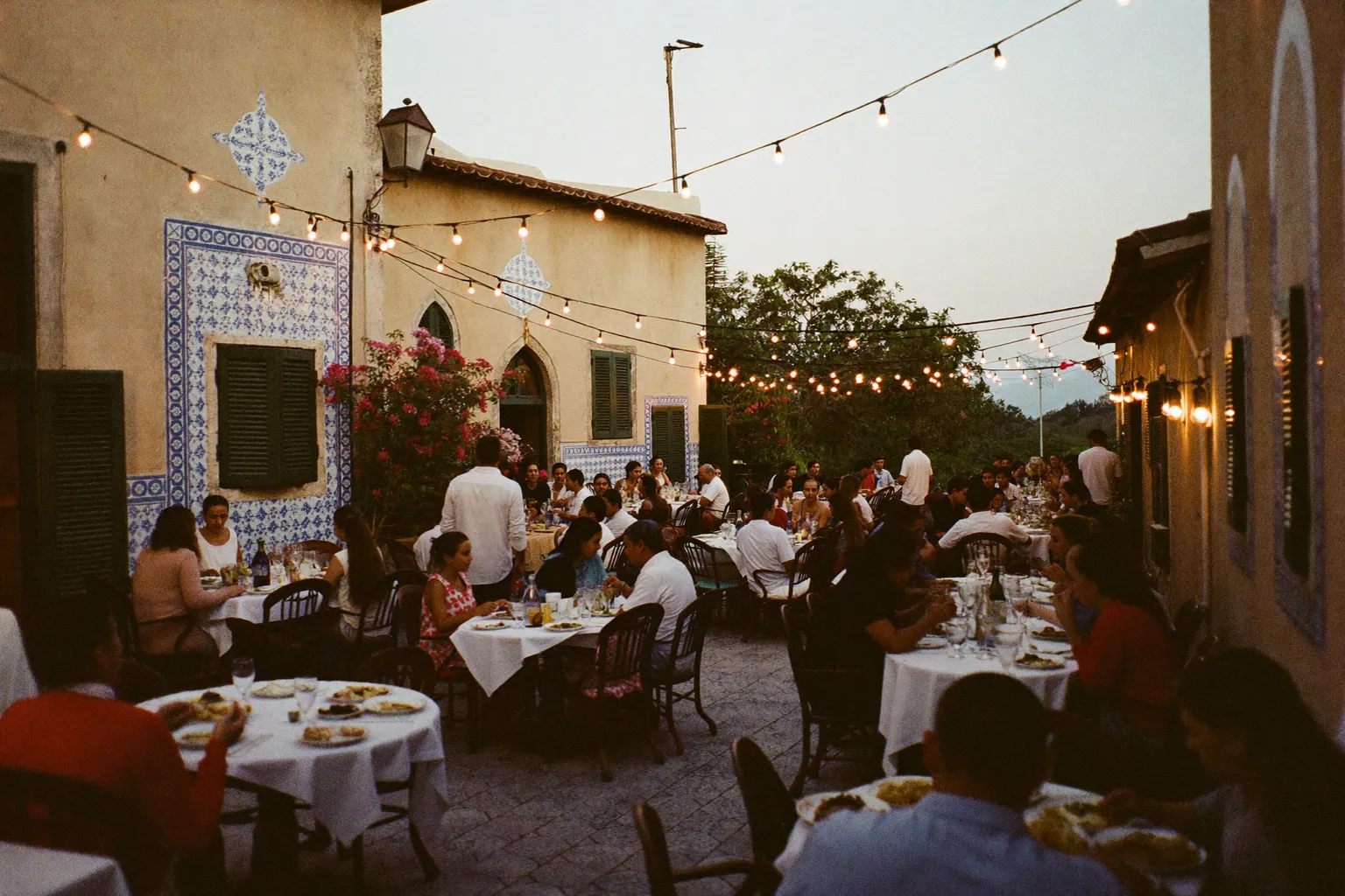 La terraza al atardecer, con focos colgados y bugambilias